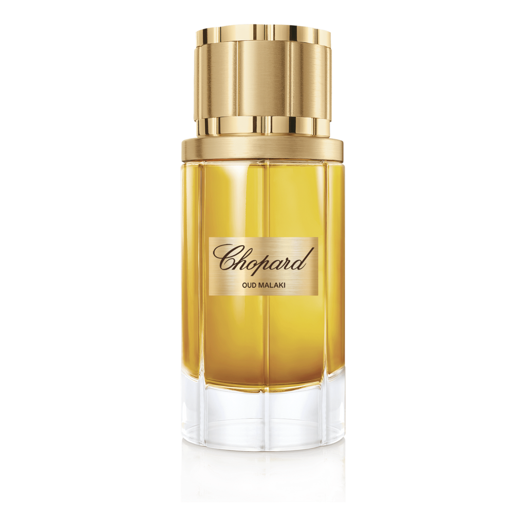 Chopard perfume bottle with gold cap on a green background