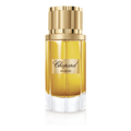 Chopard perfume bottle with gold cap on a green background