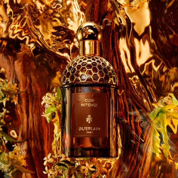 Guerlain perfume bottle with intricate design on a decorative background