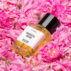 Perfume bottle labeled 'Radical Rose' by Matiere Premiere with pink flowers in the background